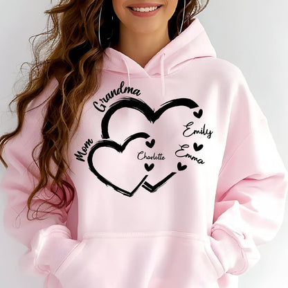 May include: Pink hoodie with a black design of two interlocking hearts. The hearts have the words "Grandma", "Mom", "Charlotte", "Emily", and "Emma" written inside them.