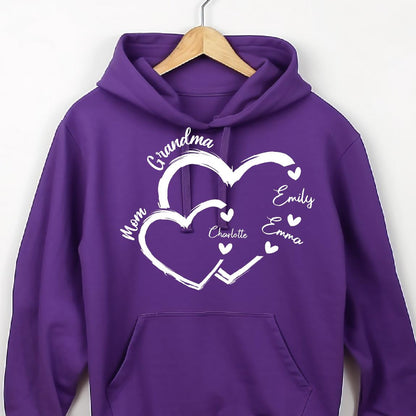 May include: Purple hoodie with a white design of two intertwined hearts. The text "Grandma" is above the hearts, and the names "Mom", "Charlotte", "Emily", and "Emma" are inside the hearts.