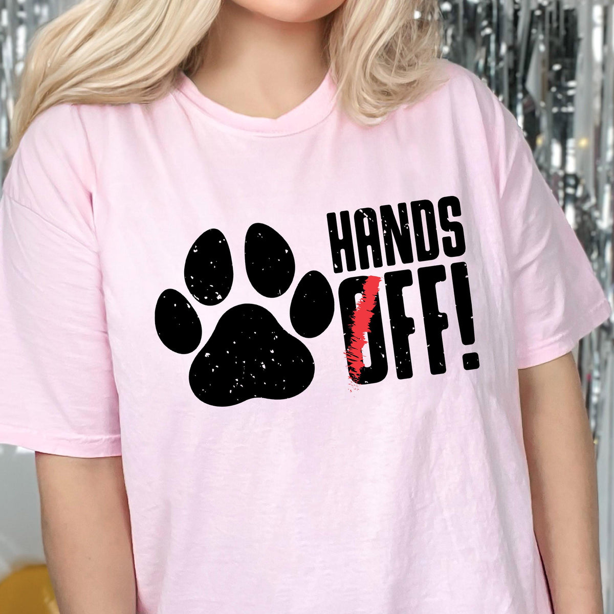 May include: Pink t-shirt with a black paw print and the text "Hands Off!" in black letters.