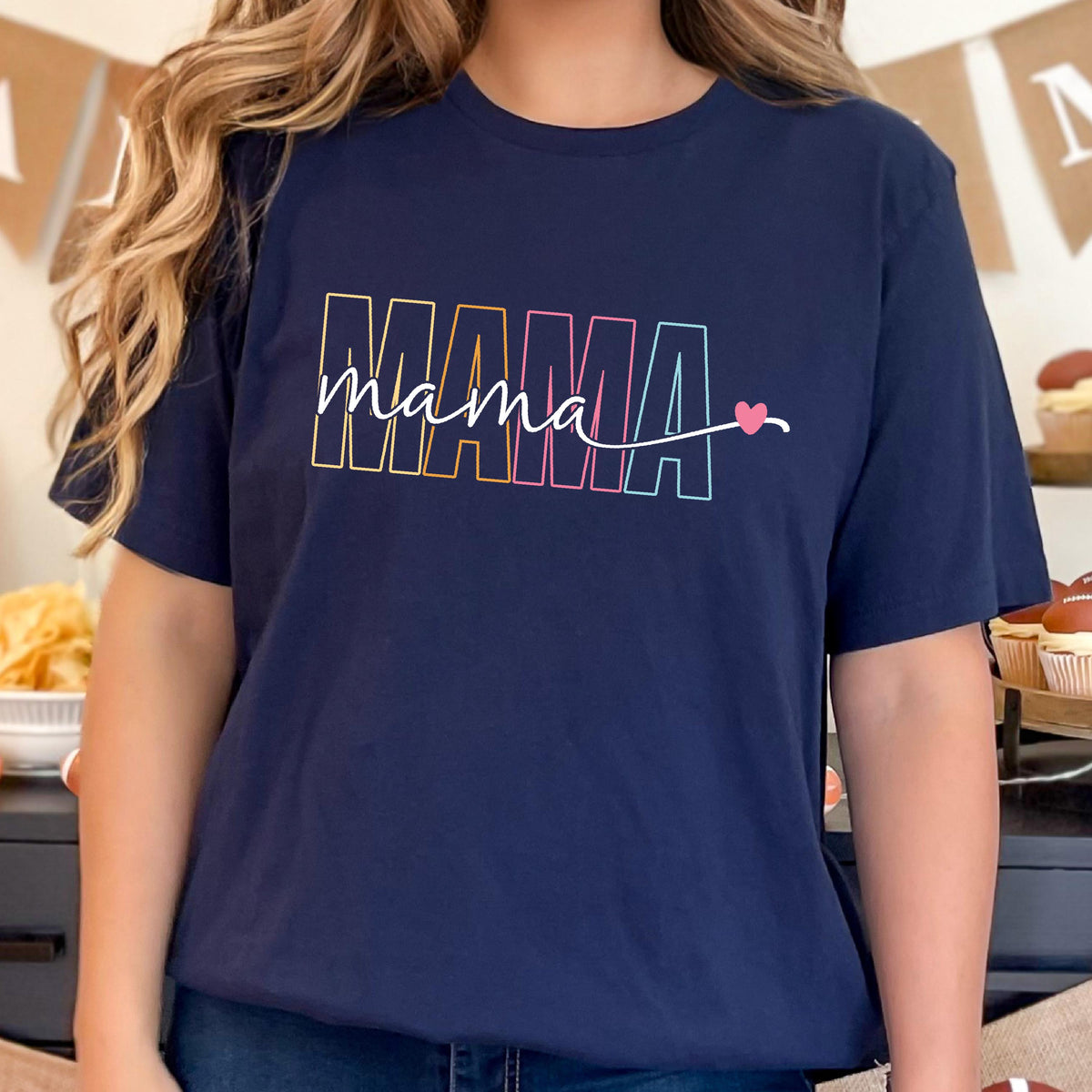 May include: A navy blue t-shirt with the word "MAMA" in rainbow colors and a small pink heart.