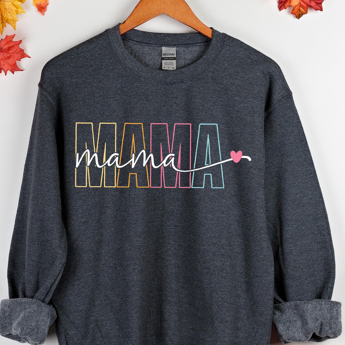 May include: A dark gray sweatshirt with the word "MAMA" in rainbow colors and a small pink heart. The word "mama" is written in cursive below the word "MAMA".