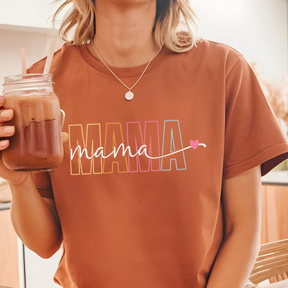 May include: A brown t-shirt with a rainbow colored "MAMA" graphic and the word "mama" written in white script with a pink heart.