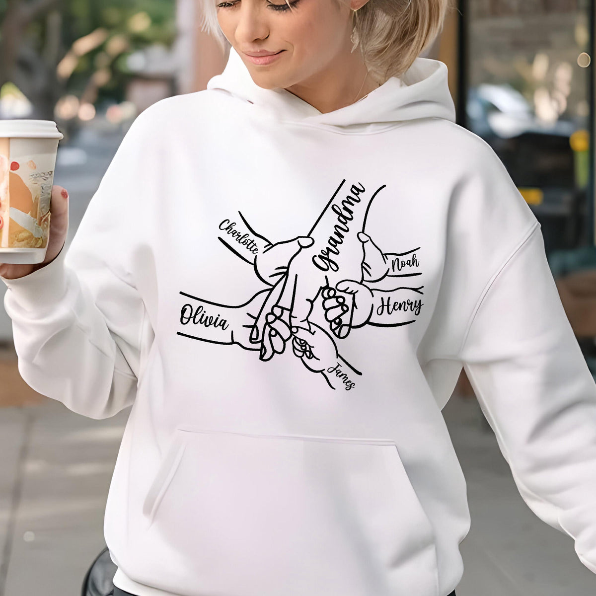 May include: White hooded sweatshirt with a black graphic of hands holding each other, with the word "Grandma" and the names "Charlotte", "Olivia", "Noah", "Henry", and "James" printed on it.