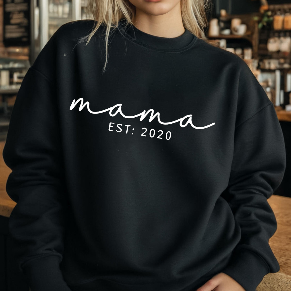 May include: Black sweatshirt with white text that reads "mama est: 2020".