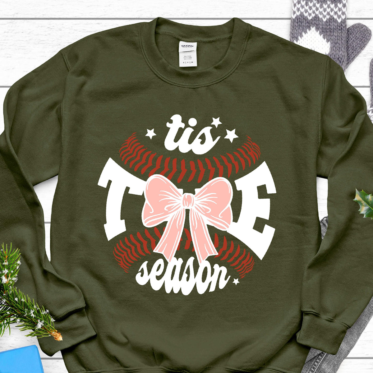 May include: Olive green sweatshirt with a white baseball graphic and the text "'tis the season" with a pink bow.