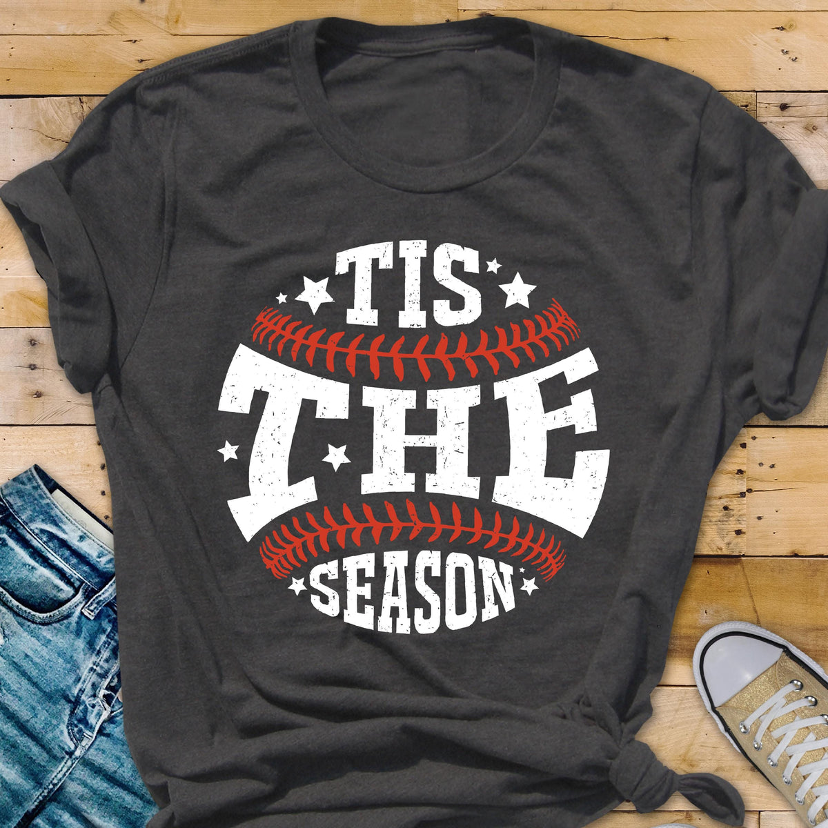 May include: A dark gray t-shirt with a white baseball graphic and the text "Tis the Season" in white.