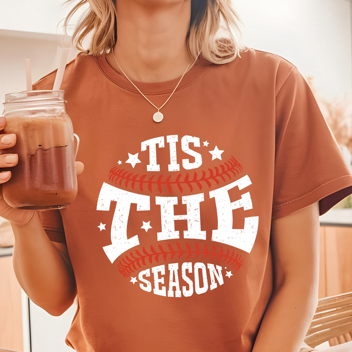 May include: A brown t-shirt with a white graphic of a baseball with the text "Tis the Season" in a distressed font.