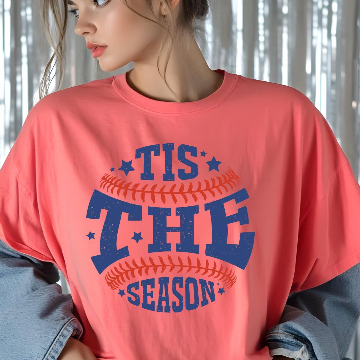 May include: A pink t-shirt with a blue and red baseball graphic and the text "Tis the Season" in a vintage style font.