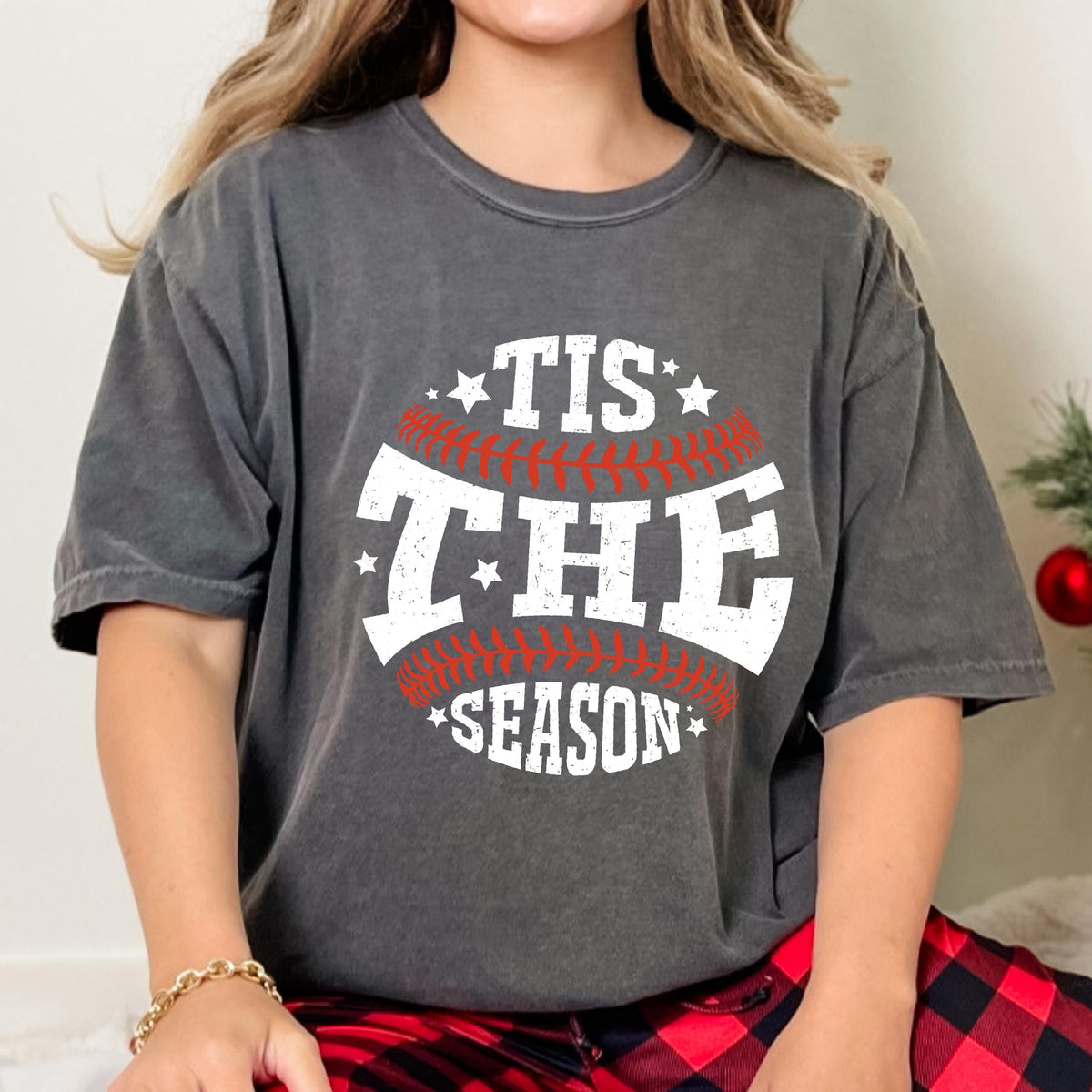 May include: A gray t-shirt with a white baseball graphic and the text "Tis the Season" in red.