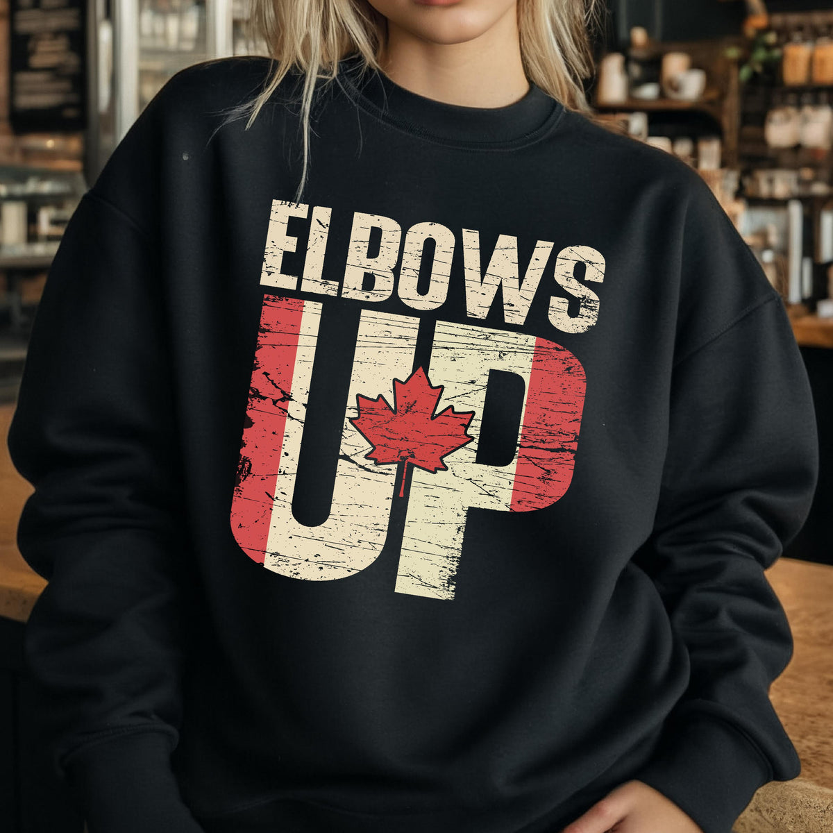 May include: Black sweatshirt with a distressed Canadian flag design and the text "Elbows Up" in white.