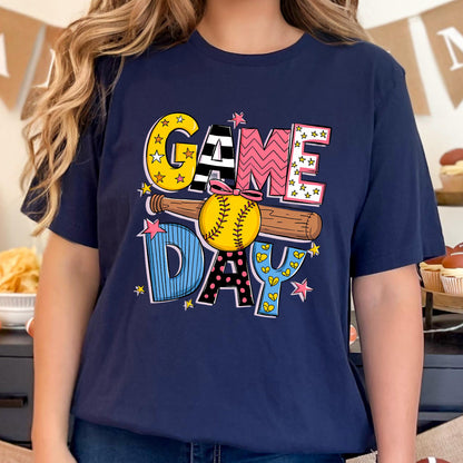May include: A navy blue t-shirt with a colorful graphic of a baseball bat and ball with the text "GAME DAY" in a playful font.