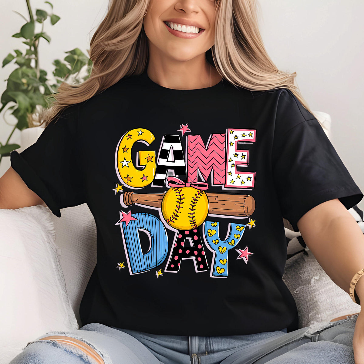 May include: Black t-shirt with a colorful graphic design that says "GAME DAY" with a baseball and bat. 