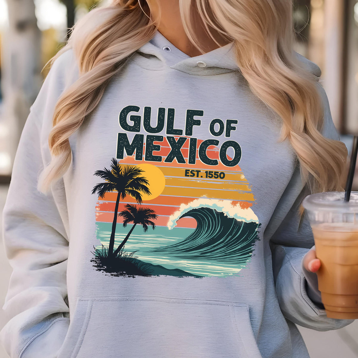 May include: Gray hooded sweatshirt with a retro-style graphic design featuring a wave, palm trees, and the text "GULF OF MEXICO EST. 1550".