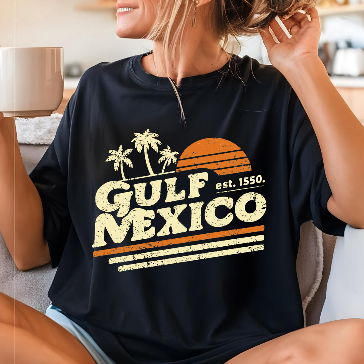 May include: Black t-shirt with a vintage-style graphic. The design features the words "GULF MEXICO" in a distressed font, with palm trees, a sunset, and the text "est. 1550."