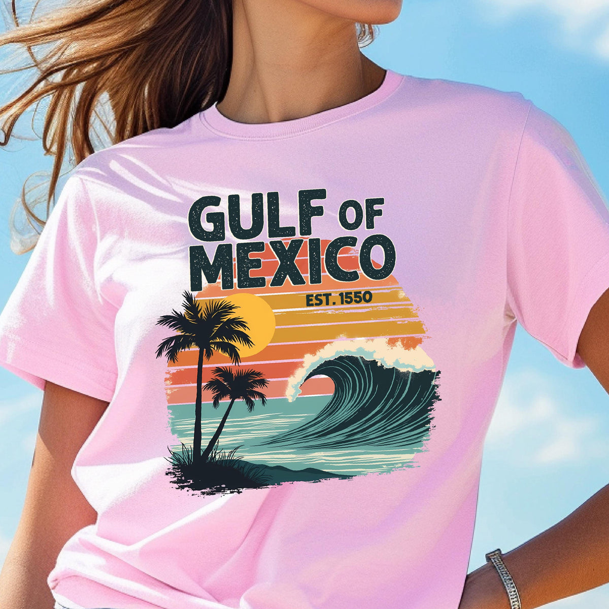 May include: Pink t-shirt with a retro graphic design featuring palm trees, a wave, and the text "Gulf of Mexico Est. 1550".