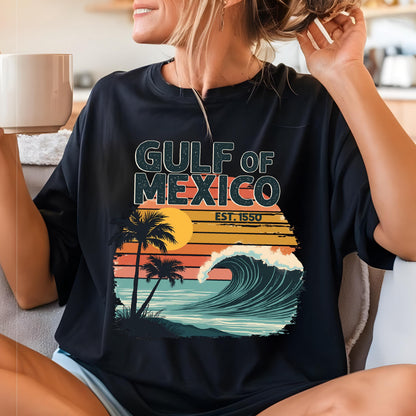 May include: Black t-shirt with a retro-style graphic of a wave crashing on a beach with palm trees and the text "GULF OF MEXICO EST. 1550".