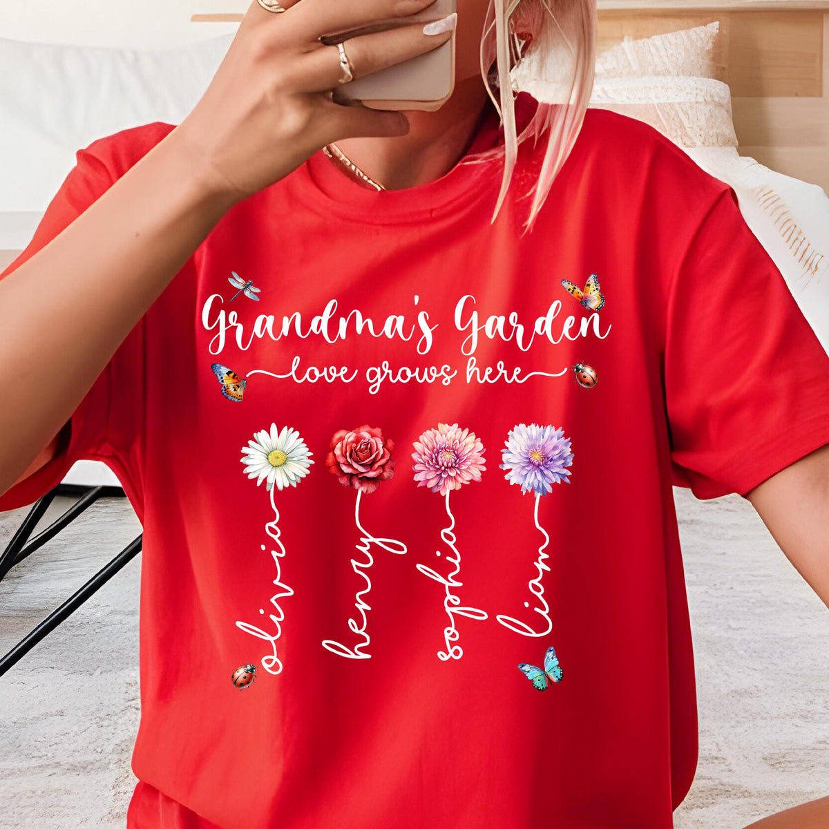 May include: Red t-shirt with the text "Grandma's Garden - love grows here" and four flowers with names Olivia, Henry, Sophia, and Liam written on them.