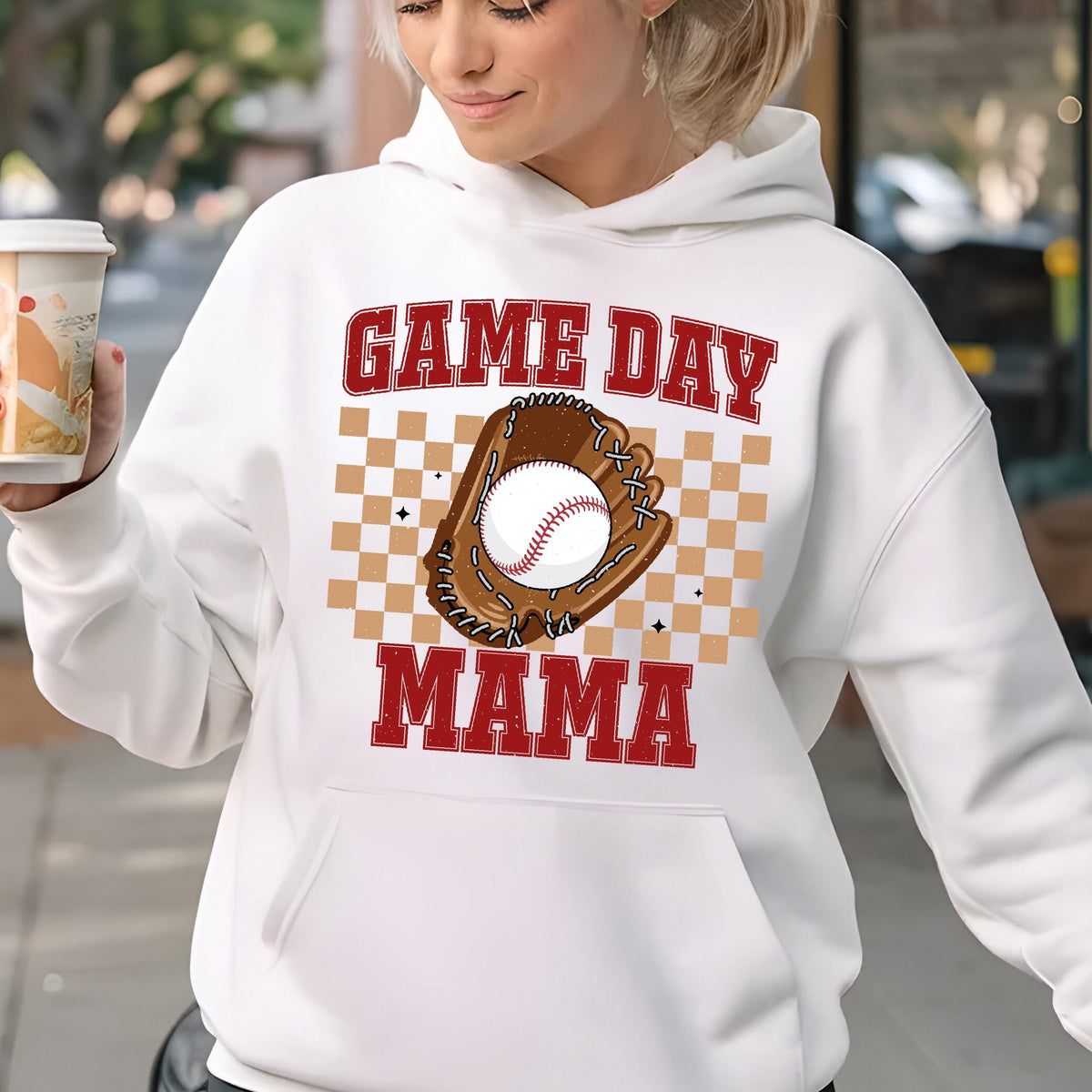 May include: White hoodie with a red and brown graphic print of a baseball in a glove. The text "GAME DAY MAMA" is printed on the hoodie.