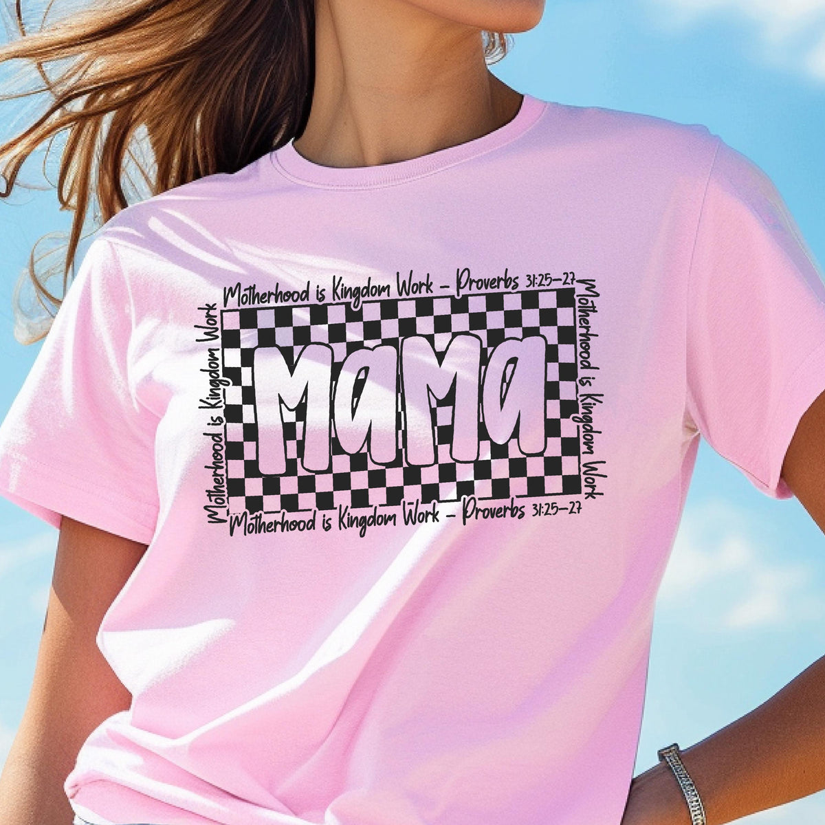 May include: Pink t-shirt with a black and white checkered design and the word "Mama" in a pink and white gradient. The text "Motherhood is Kingdom Work - Proverbs 3:25-27" is repeated around the checkered design.