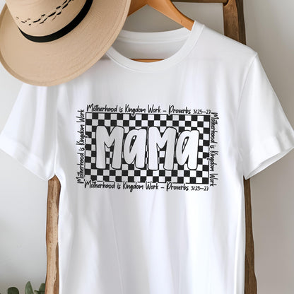 May include: White t-shirt with a black and white checkered design and the word "Mama" in bold, black letters. The text "Motherhood is Kingdom Work - Proverbs 3:25-27" is printed on the top and bottom of the checkered design.