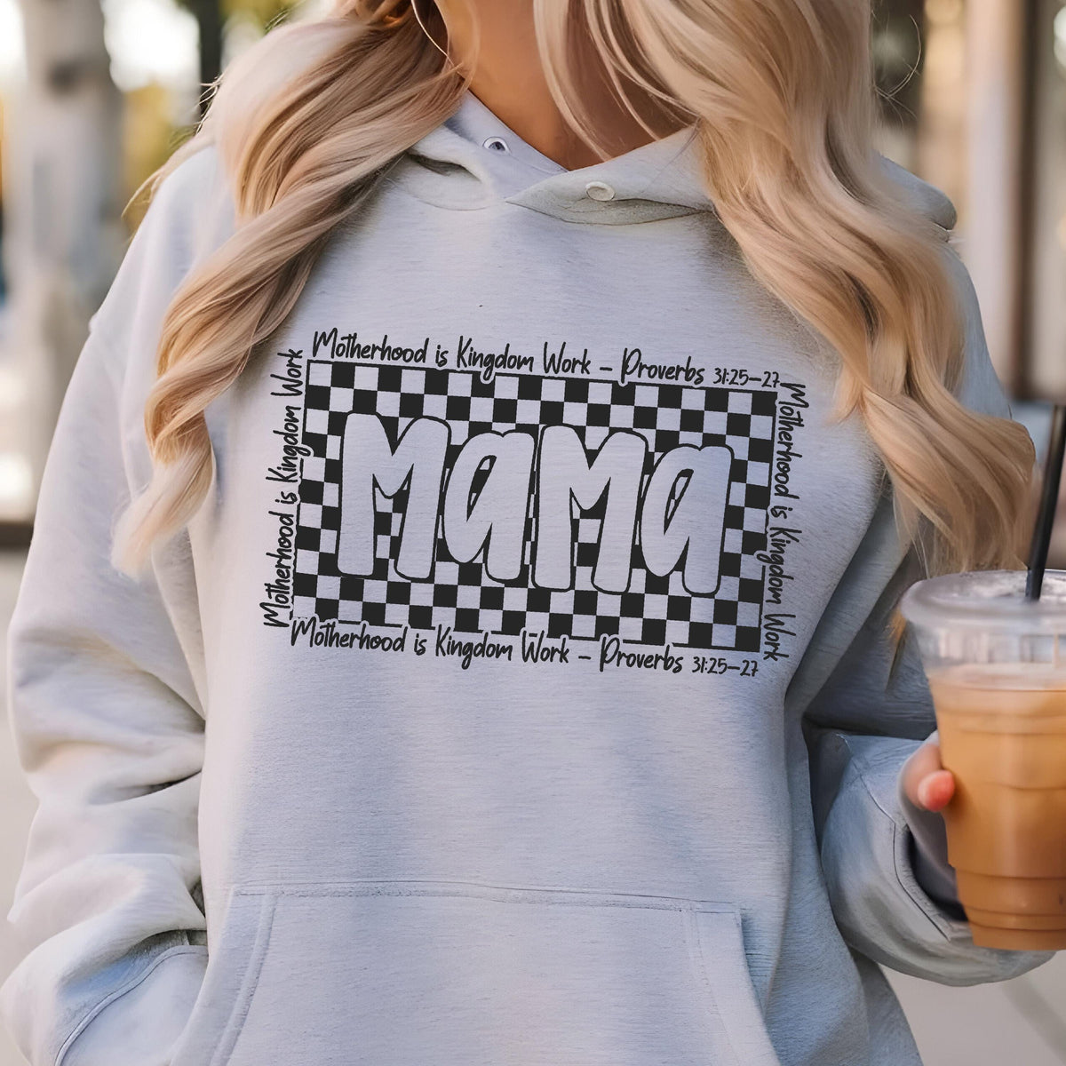 May include: Gray hooded sweatshirt with a black and white checkered design and the word "Mama" in a bold, white font. The text "Motherhood is Kingdom Work - Proverbs 3:25-27" is repeated around the checkered design.