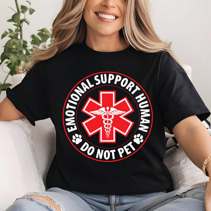 May include: Black t-shirt with a red and white graphic. The graphic features a red medical symbol with a caduceus in the center, surrounded by the words "EMOTIONAL SUPPORT HUMAN" and "DO NOT PET".