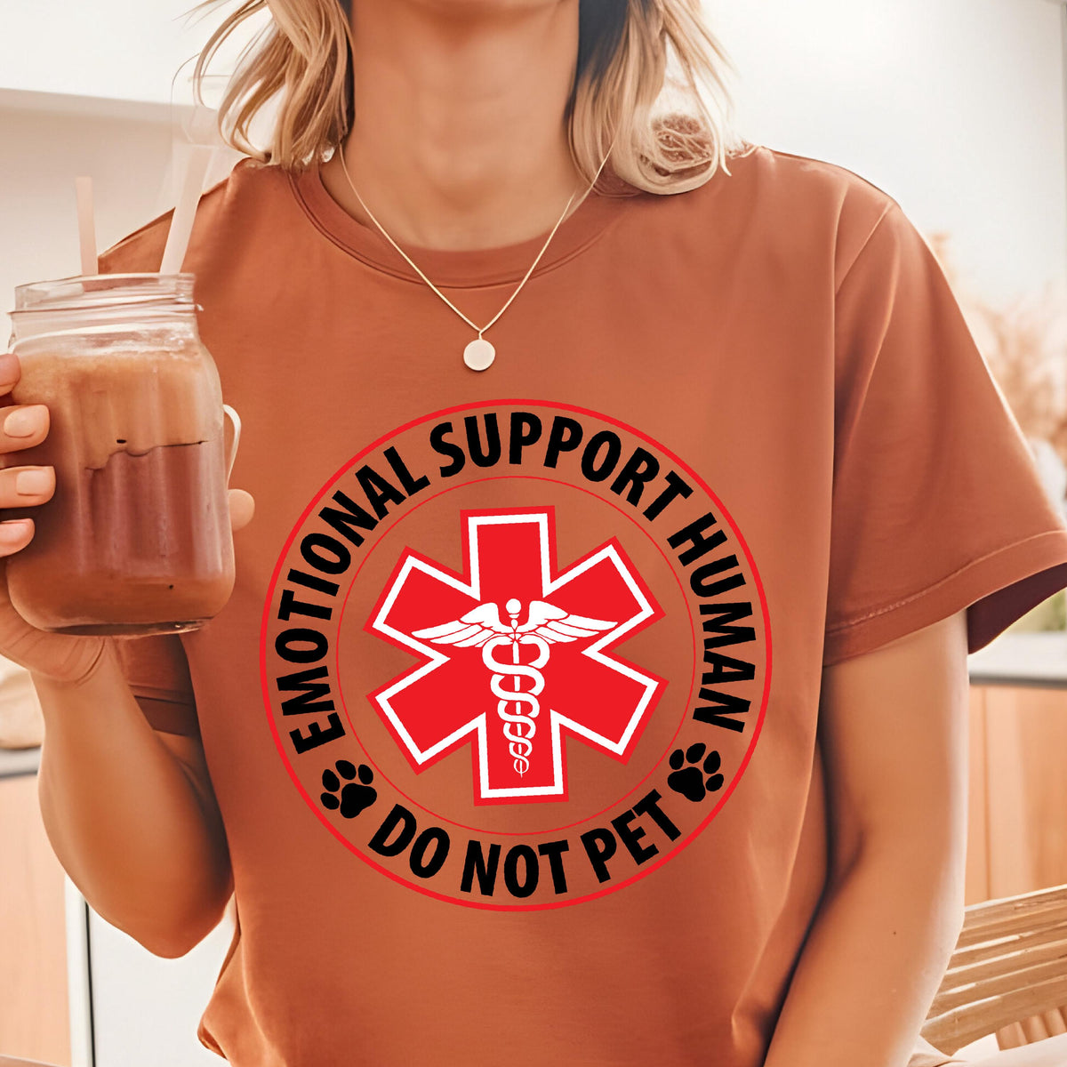 May include: A brown t-shirt with a white circle graphic that says "Emotional Support Human Do Not Pet" with a red medical symbol in the center.