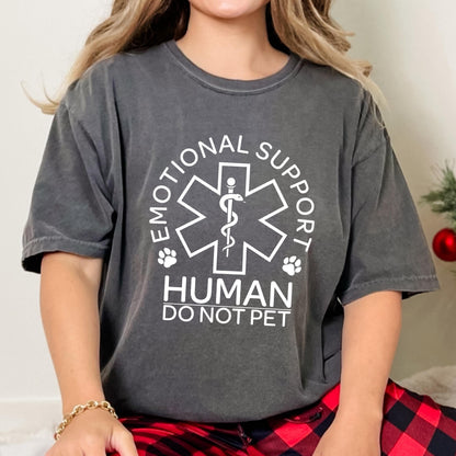 May include: A charcoal gray short-sleeve t-shirt featuring a white graphic of a Star of Life symbol with a snake and staff, flanked by two paw prints. The text reads EMOTIONAL SUPPORT HUMAN DO NOT PET in a bold, white, sans-serif typeface.