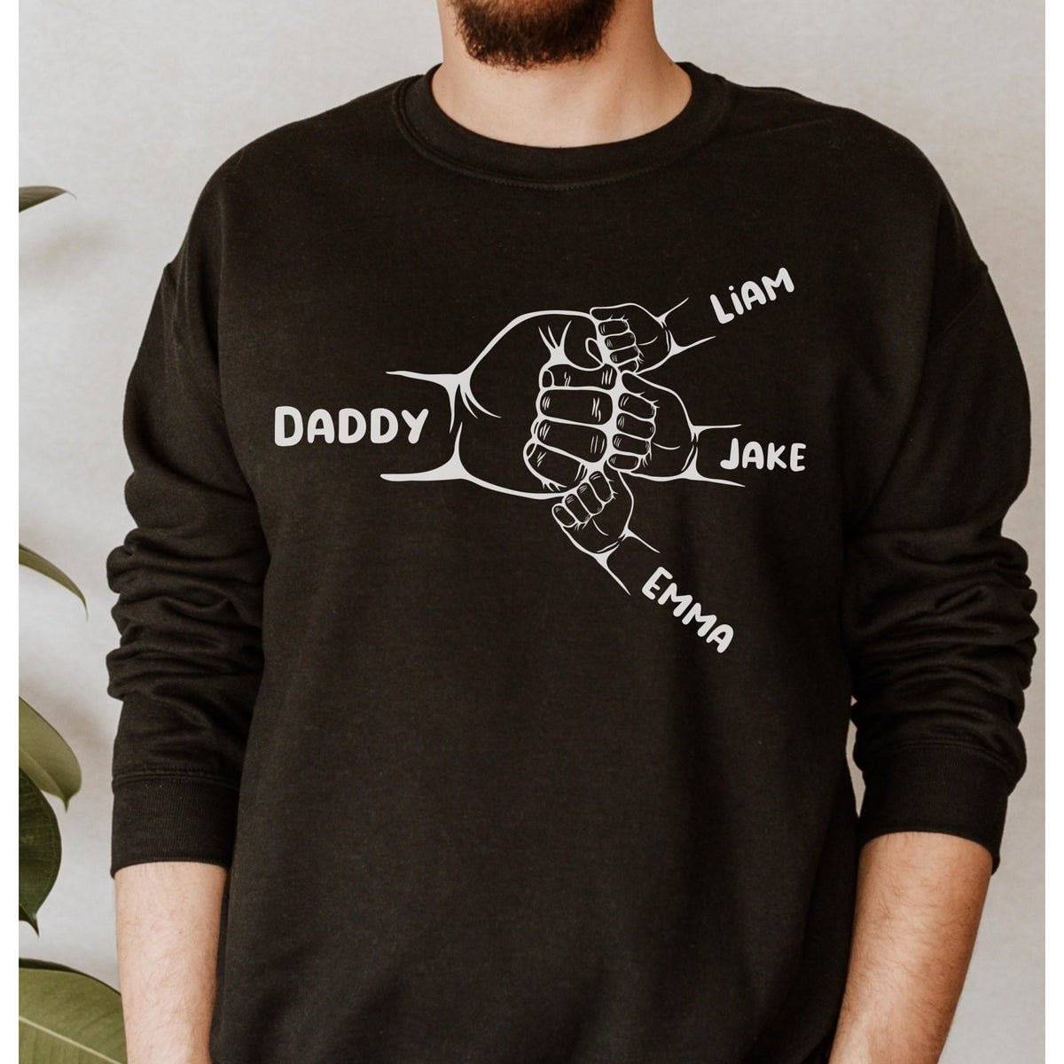 May include: Black sweatshirt with a white graphic of five hands clasped together. The hands are labeled "Daddy", "Liam", "Jake", and "Emma".