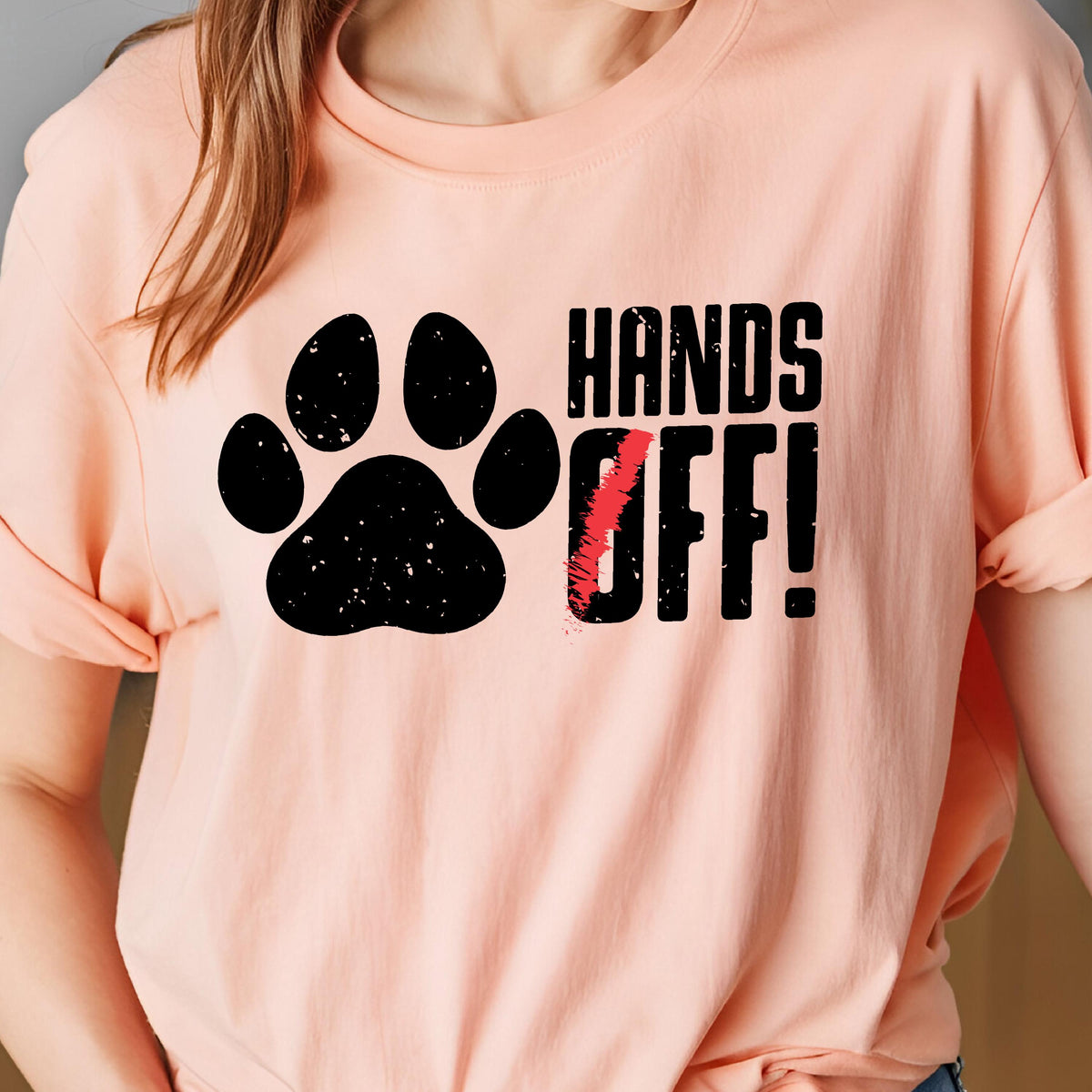 May include: A pink t-shirt with a black paw print and the text "HANDS OFF!" in black.