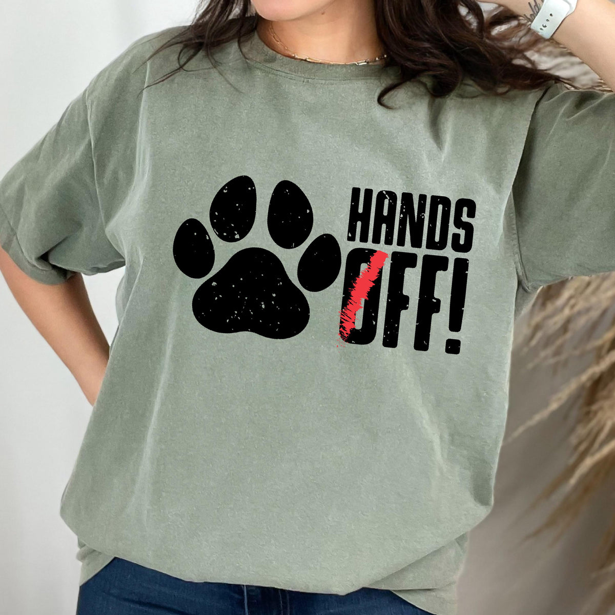 May include: A green t-shirt with a black paw print and the text "Hands Off!" in black.