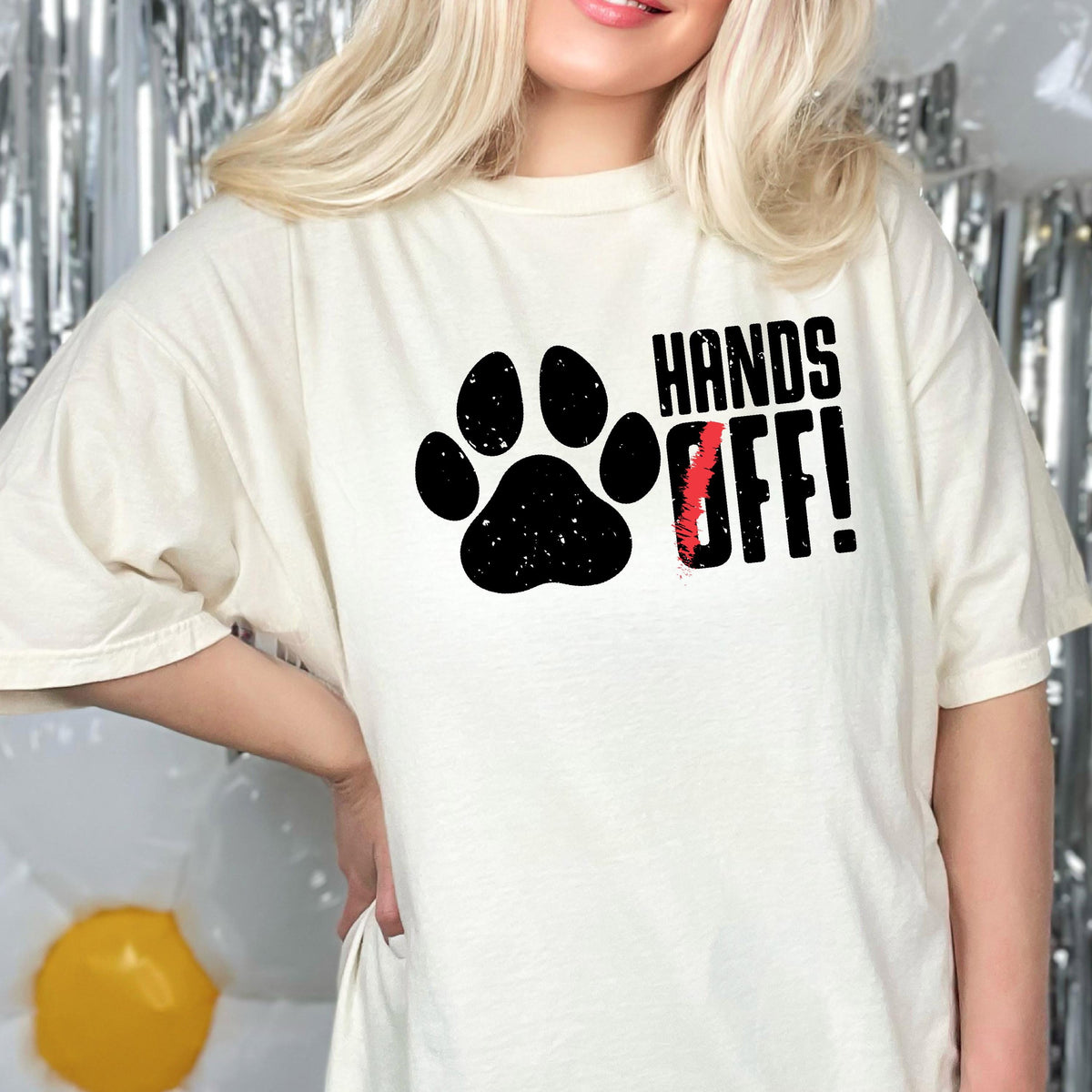 May include: A white t-shirt with a black paw print and the text "HANDS OFF!" in black with a red slash through the "O".