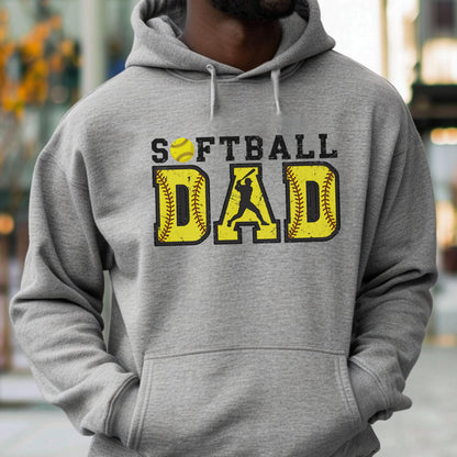 May include: A gray hooded sweatshirt with the words "SOFTBALL DAD" printed on the front. The word "DAD" is in yellow with a baseball design. The word "SOFTBALL" is in black with a yellow softball graphic.