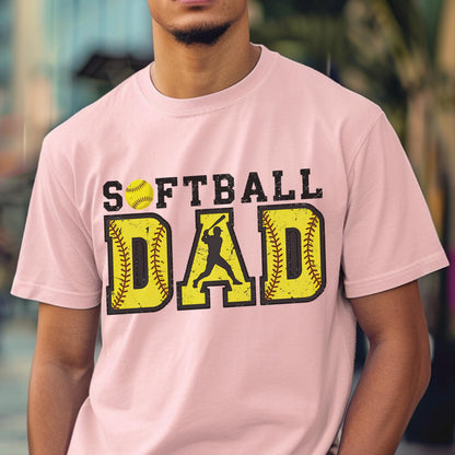 May include: Pink t-shirt with the text "Softball Dad" in black letters. The text is surrounded by two yellow softball graphics with red stitching. A silhouette of a softball player is in the middle of the text.