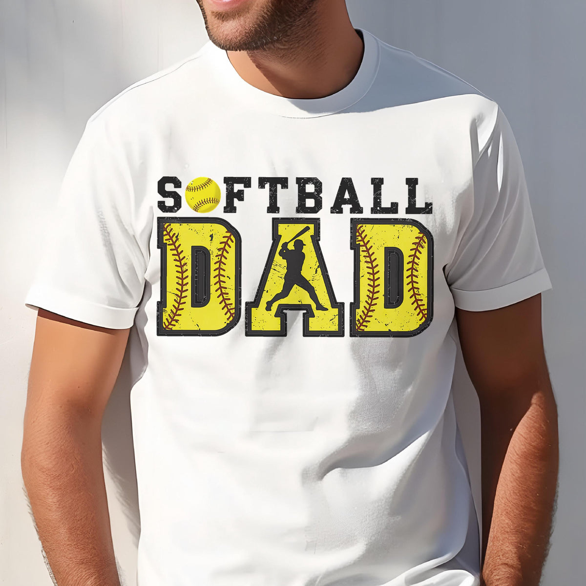 May include: White t-shirt with the text "Softball Dad" in yellow with a baseball graphic and a silhouette of a softball player.