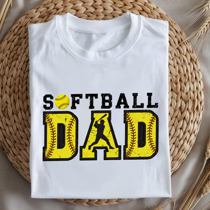 May include: White t-shirt with the text "Softball Dad" in black and yellow. The text is stylized with a baseball graphic and a silhouette of a player.