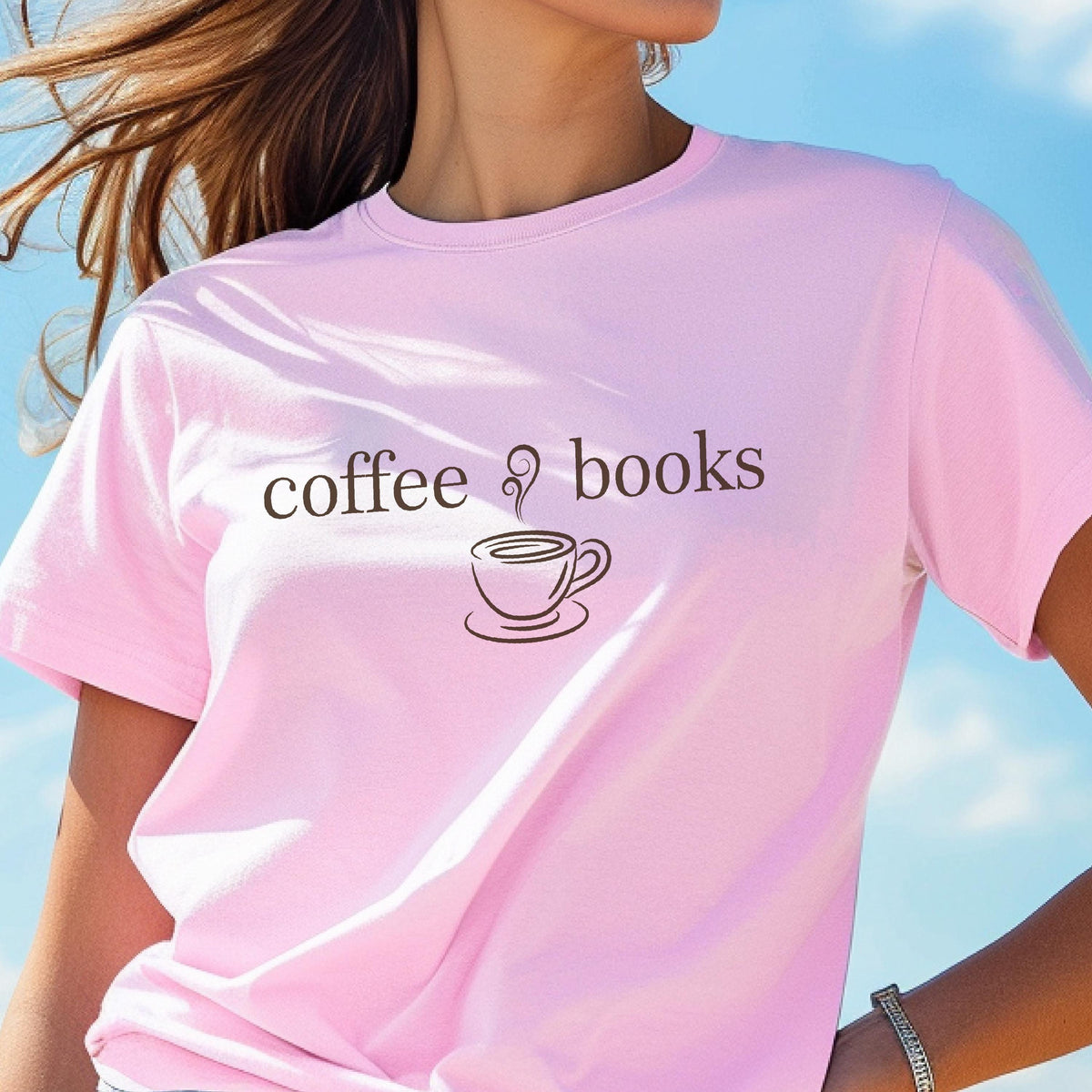 May include: A light pink t-shirt with the words "coffee & books" printed in brown. A coffee cup graphic is between the words. The shirt is short-sleeved and made of a soft material.