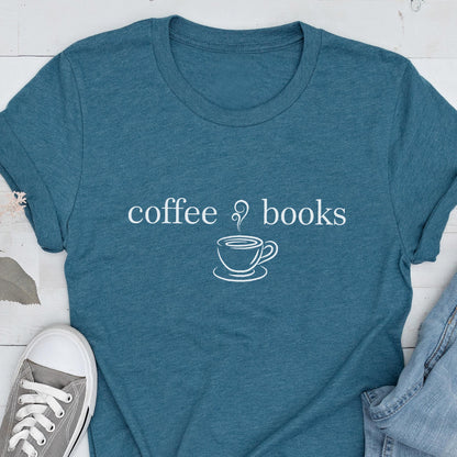 May include: Teal t-shirt with the words "coffee & books" and a coffee cup graphic in white. The shirt is made of a soft material and has short sleeves. A gray sneaker and denim are partially visible.