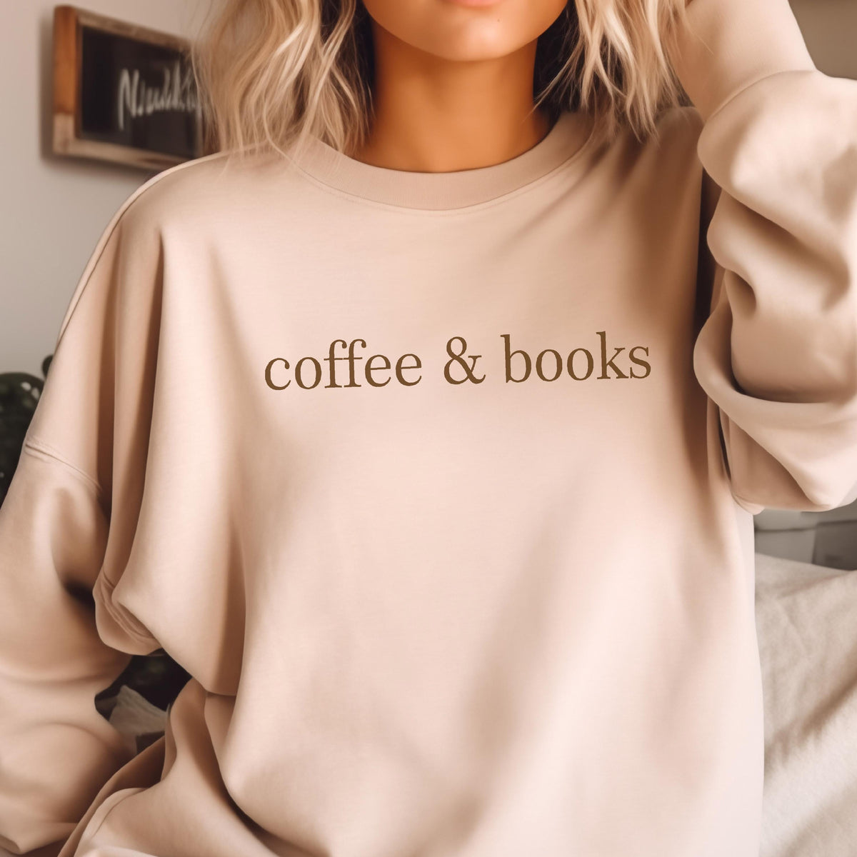 May include: A light beige sweatshirt with the text "coffee & books" printed in brown on the front.