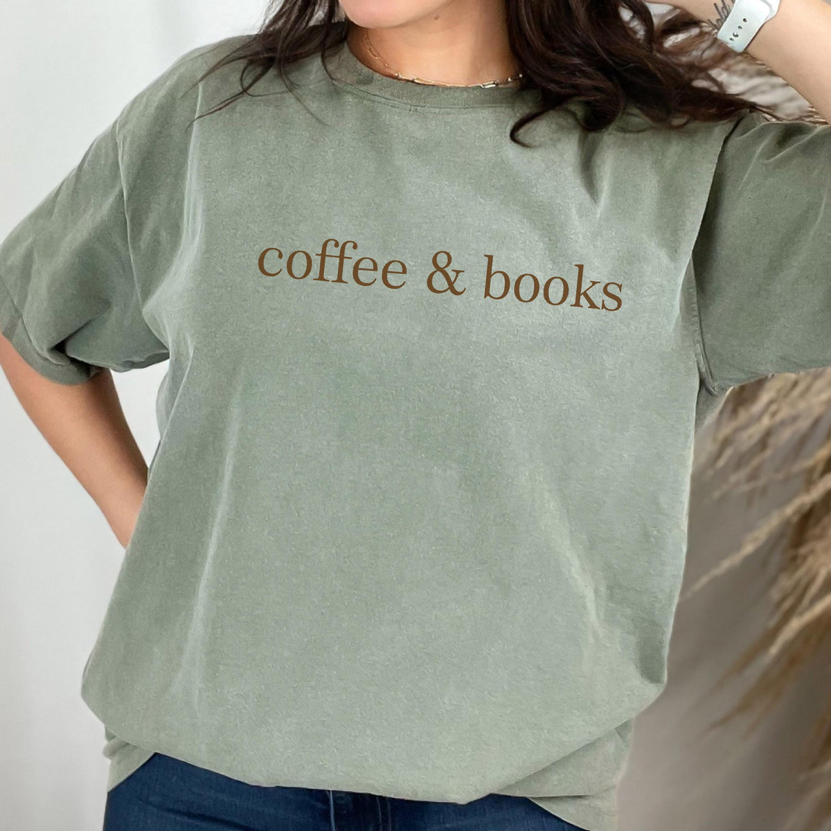 May include: A sage green t-shirt with the text "coffee & books" printed in brown on the front.