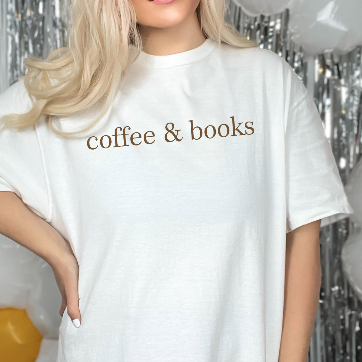 May include: White t-shirt with the text "coffee & books" printed in brown on the front.