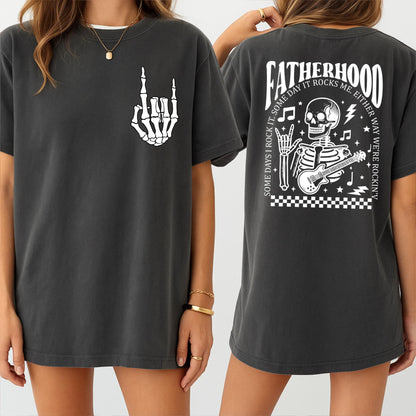 May include: A dark gray t-shirt with a skeleton playing a guitar and the text "Fatherhood. Some days I rock it. Some day it rocks me. Either way we're rockin'" on the back. The front of the shirt has a skeleton hand making a rock and roll sign.