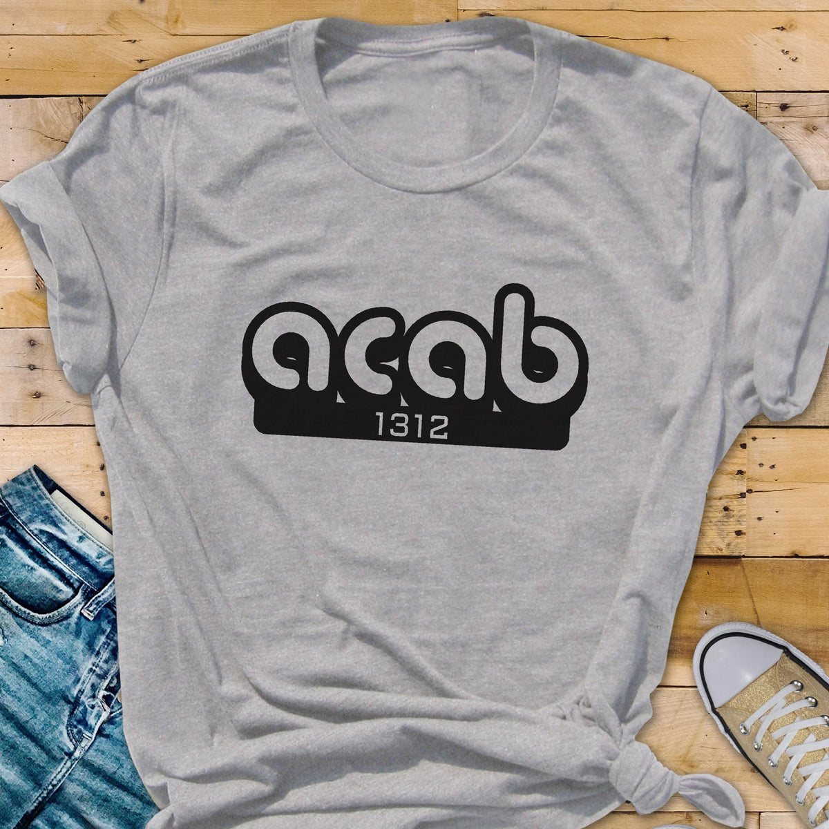 May include: A gray t-shirt with a black graphic that says "ACAB" with the number "1312" underneath.