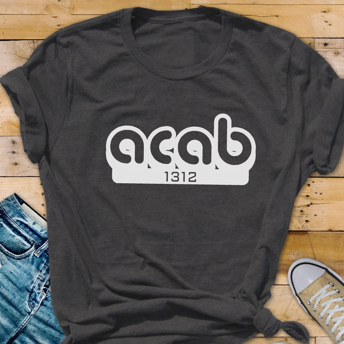 May include: A dark gray t-shirt with a white graphic that says "ACAB" with the number "1312" underneath.