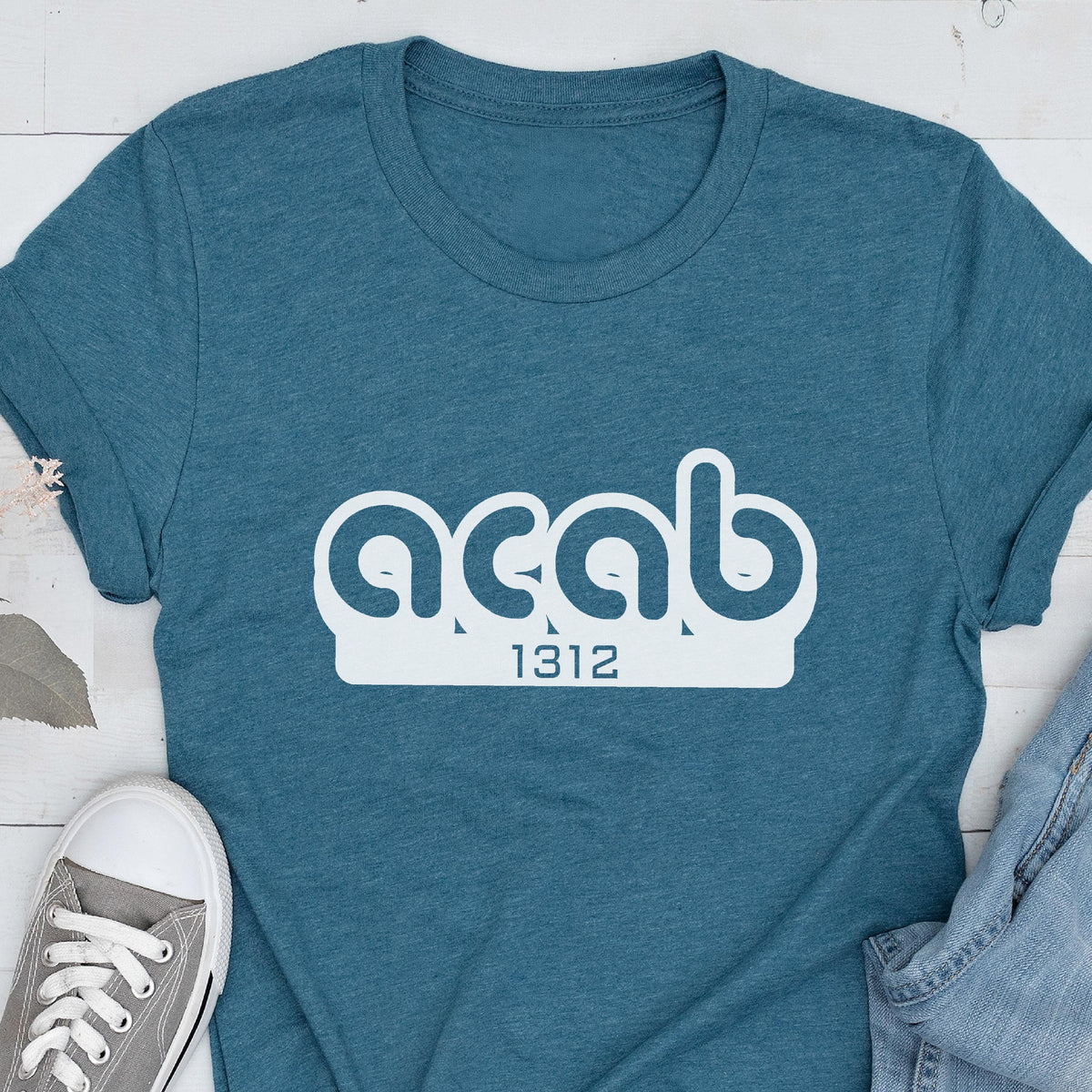 May include: A teal blue t-shirt with white text that reads "acab 1312".
