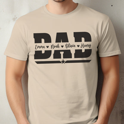 May include: A beige t-shirt with a black graphic that says "DAD" in bold letters. Below the word "DAD" are the names "Emma", "Noah", "Olivia", and "Henry", each with a heart symbol. A star is below the word "DAD".