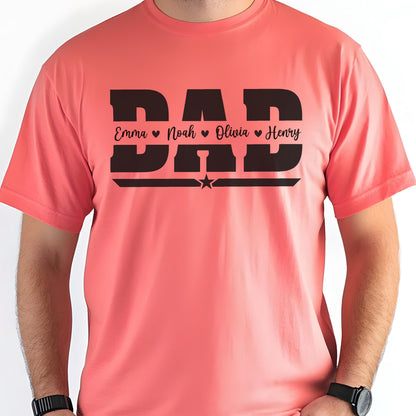 May include: Coral-colored t-shirt with the word "DAD" in large, bold, black letters. Below the word "DAD" are the names "Emma", "Noah", "Olivia", and "Henry" in a smaller font. A black star is centered below the names.