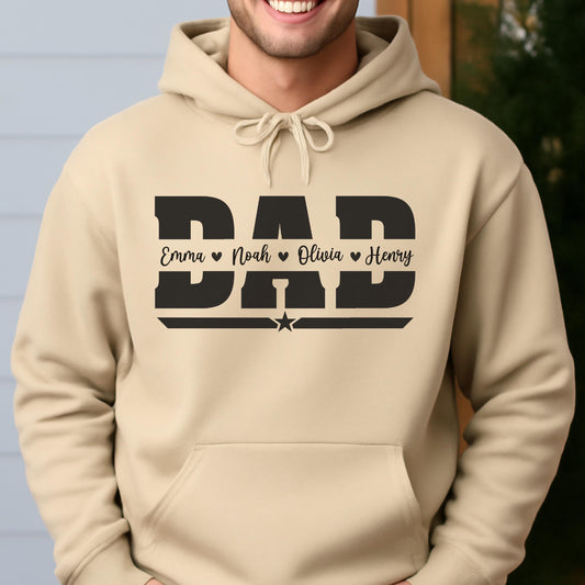 May include: A tan hoodie with a black graphic that says "DAD" in bold letters. Below the word "DAD" are the names Emma, Noah, Olivia, and Henry, each separated by a heart symbol. A star is below the names.