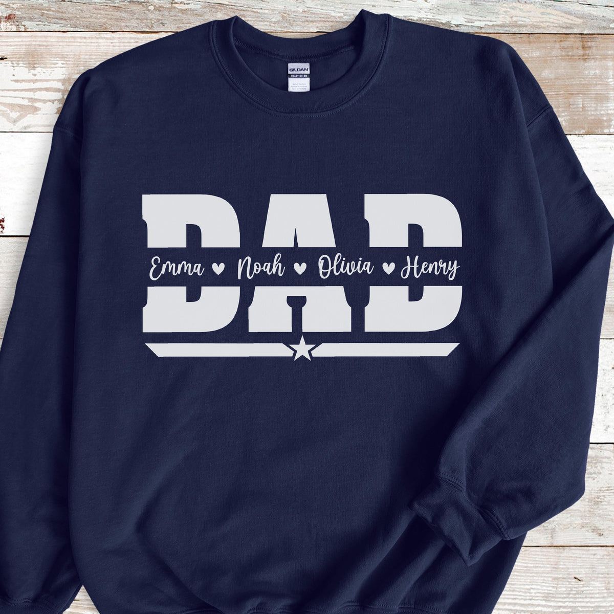 May include: Navy blue sweatshirt with the word "DAD" in large white block letters. Below the word "DAD" are the names Emma, Noah, Olivia, and Henry, each separated by a heart symbol. A white star is below the word "DAD".