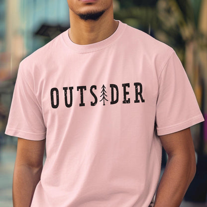 May include: A light pink short-sleeved t-shirt featuring the word OUTSIDER printed in black, distressed capital letters across the chest, with a stylized black pine tree graphic replacing the letter I in the center of the word.